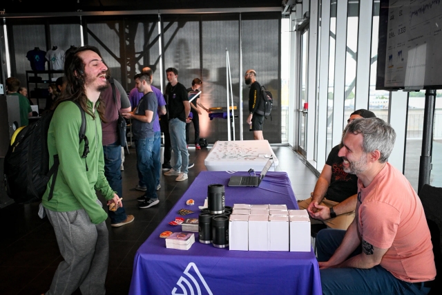 A guest laughing with the representatives from Sentry at their sponsor booth.