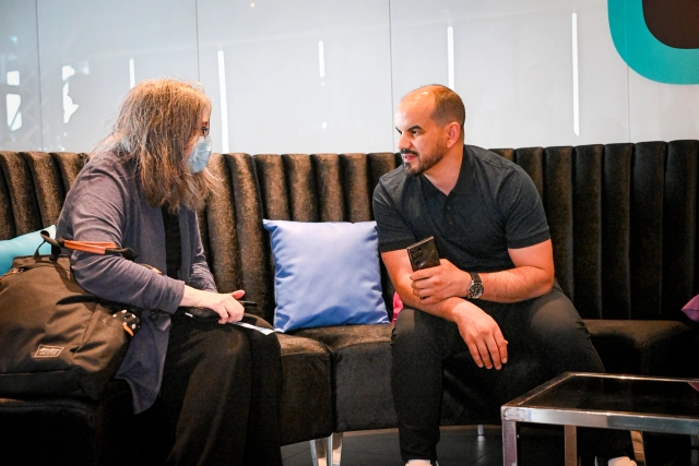 A woman and a man speaking intently to one another while sitting in the lounge.