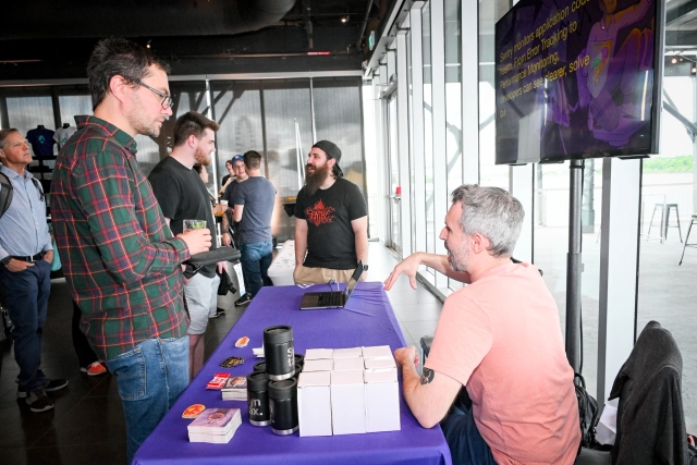 Guests talking to Sentry at their sponsor booth.