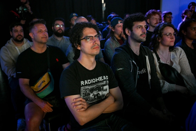 Audience members listening to Sarah Rainsberger speaking on stage.