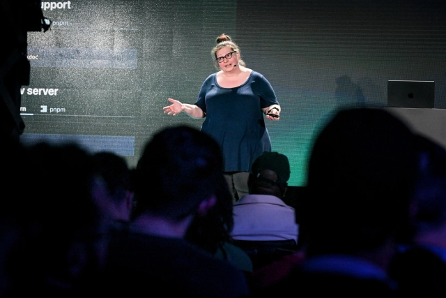 View from the audience of Sarah Rainsberger speaking on stage.