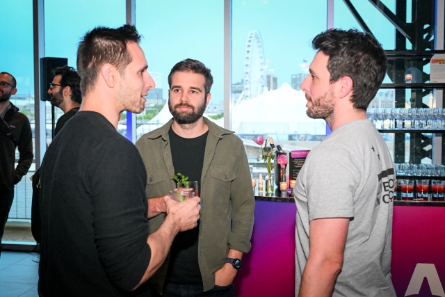 Guests mingling with their drinks in front of the alcohol bar.