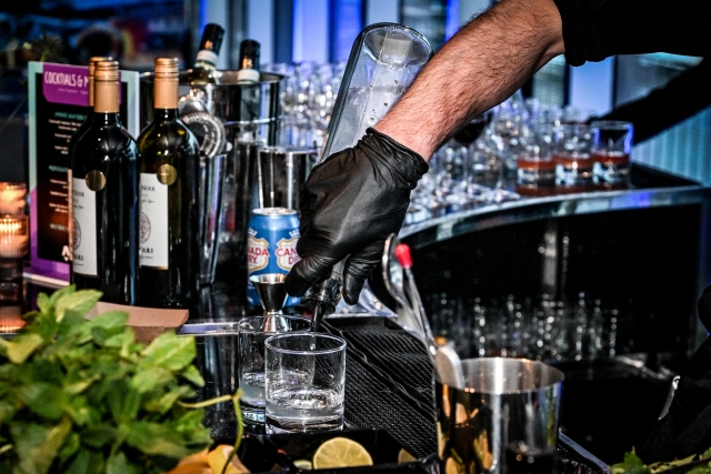 Closeup of a bartender pouring a drink.